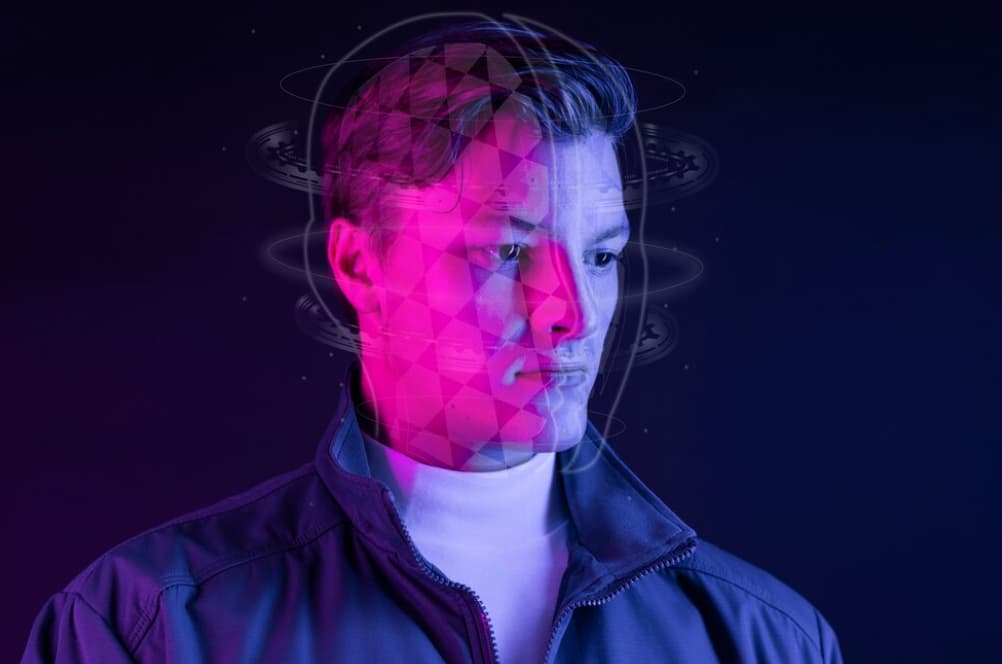 Man with a digital grid overlay on his face against a purple background